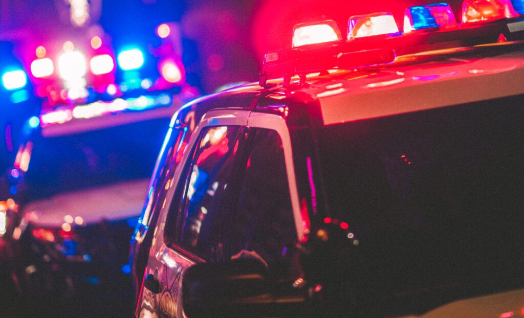 Two police vehicles with their lights turned on at night time.